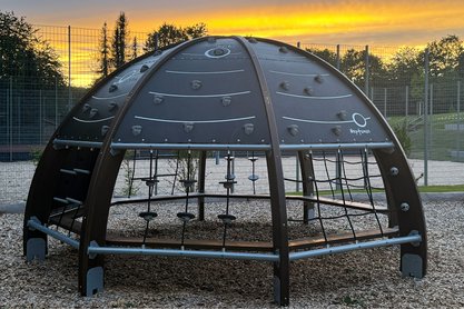 Klettergerüst im Thema Planetarium, im Hintergrund die Sonne die untergeht