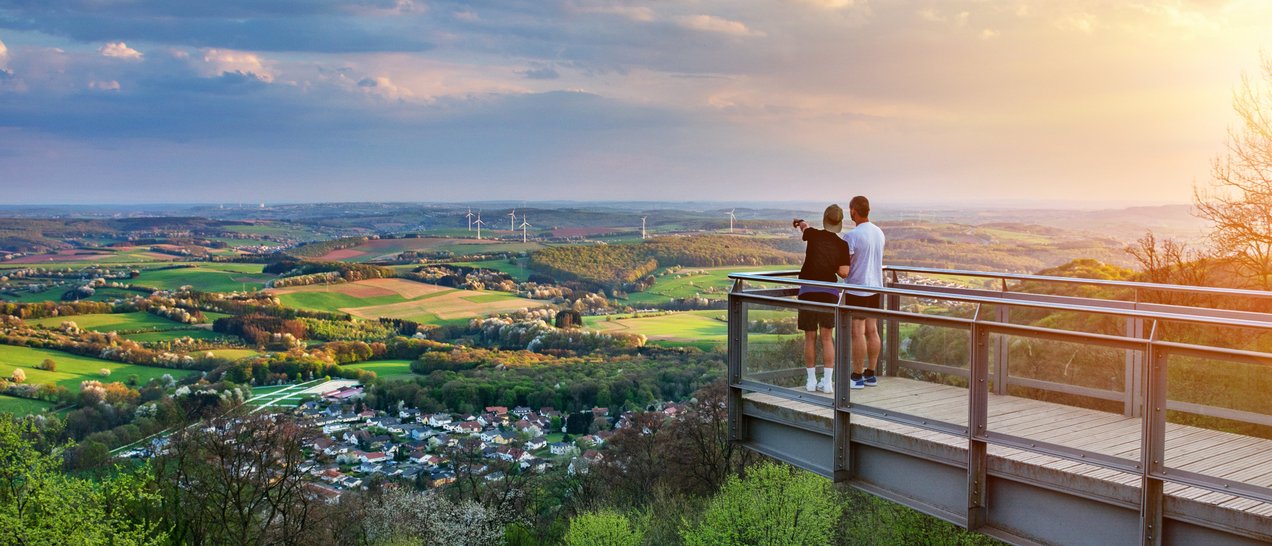 Zwei Personen auf der Aussichtsplattform am Schaumberg mit Blick über das ganze Sankt Wendler land